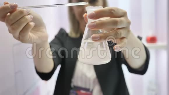 化验师在试验液体护生产中灌注化妆品油视频的预览图