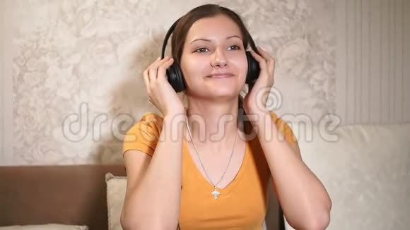 美丽快乐的女孩听音乐耳机戴着耳机快关门家庭休闲技术视频的预览图