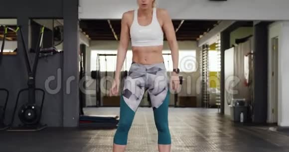 一名运动白人妇女用战绳锻炼身体视频的预览图