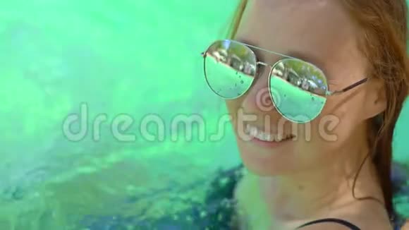 一位年轻女子在热带度假胜地有温泉瀑布和游泳池有热水视频的预览图