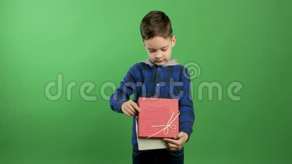 惊讶的孩子打开凝视着一个神奇的礼物在一个孤立的绿色背景视频的预览图