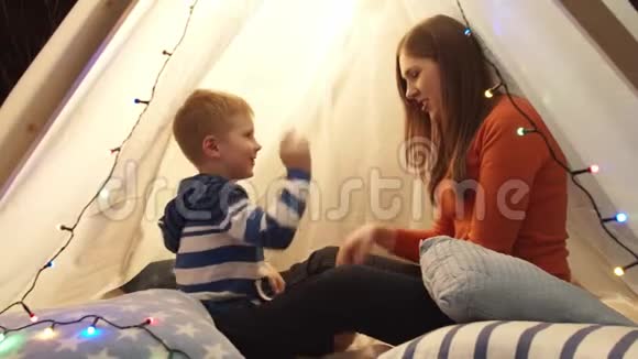 小男孩在家里的儿童帐篷里和妈妈玩快乐的白种人小孩在游戏室视频的预览图