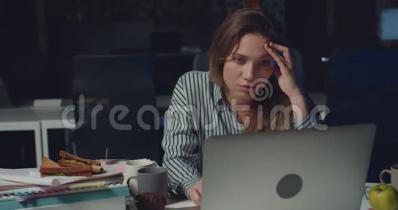 疲惫的女人独自在黑暗的办公室工作深夜一个被压迫的女孩仰着头摸着脸哭着视频的预览图