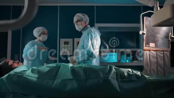 两位外科医生讨论手术室的病人治疗视频的预览图