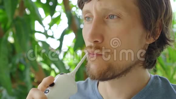 一个年轻人用便携式水牙线口腔冲洗器清洁牙齿视频的预览图