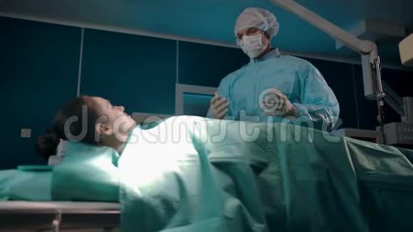 专业外科医生在手术前在局部麻醉下安抚女性患者视频的预览图