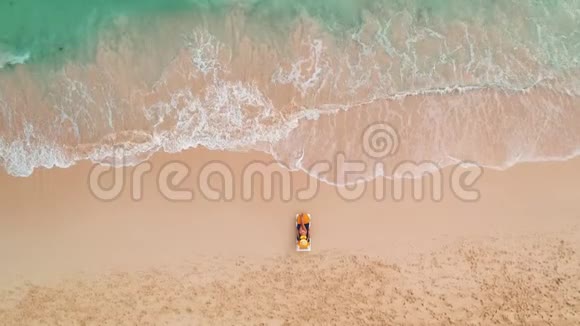 海滩度假在天堂热带岛屿性感的阳光女人放松在海滩和海洋高空俯视图视频的预览图