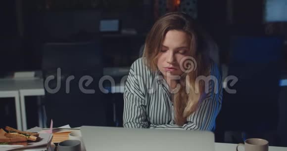 疲惫的美丽女人在深夜办公室里看镜头的肖像美女办公室经理视频的预览图