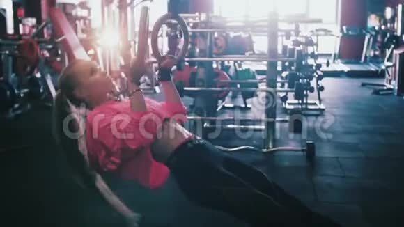 在交叉健身馆用体操戒指锻炼的女孩视频的预览图
