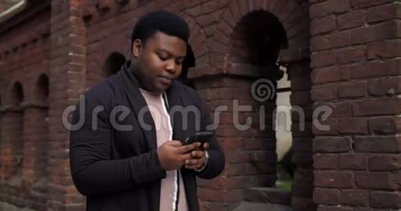 胖子用智能手机微笑着走在城市街道上动画与用户界面与跟随者评论视频的预览图