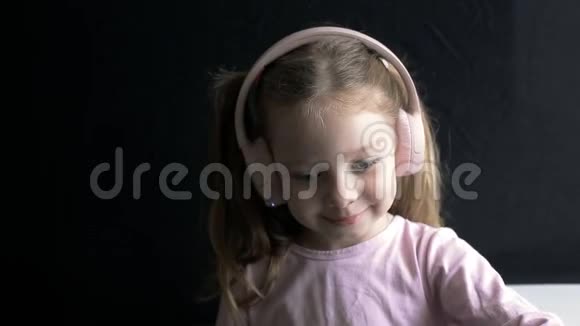 戴着耳机听音乐的小女孩一个高加索儿童的肖像视频的预览图