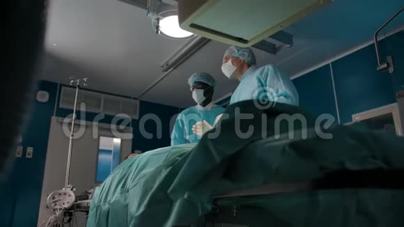 两名外科医生移动一台X光机进行手术视频的预览图