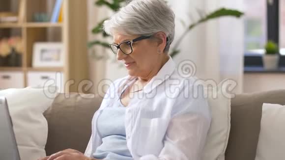 快乐的老女人在家打手提电脑视频的预览图