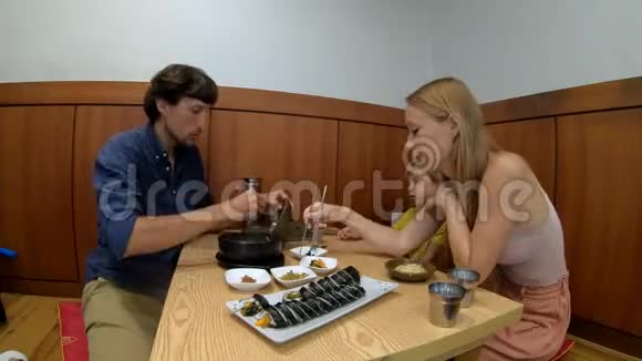 一家人在餐馆里享用传统的韩国食品面条和Kimpa视频的预览图