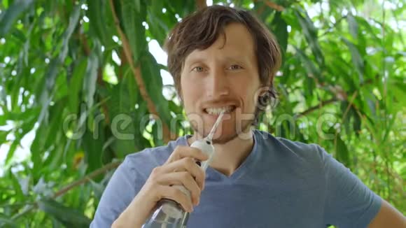 一个年轻人用便携式水牙线口腔冲洗器清洁牙齿视频的预览图