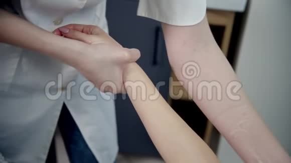 按摩按摩治疗师是揉捏女人的前臂视频的预览图