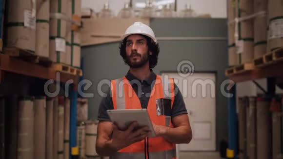 与大型配送用品之间的数字平板电脑行走清单相比仓库中的男性工人视频的预览图