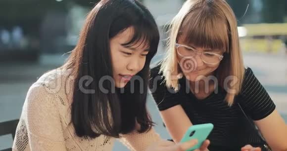 两个女人在看智能手机的照片视频的预览图