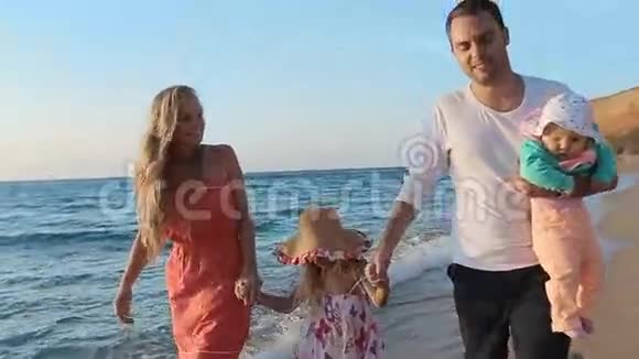 友好的家庭慢慢地沿着海岸散步视频的预览图