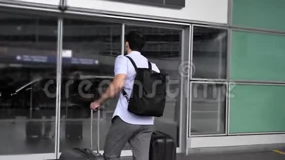 一个商人在机场里推着一个手推车手提箱视频的预览图