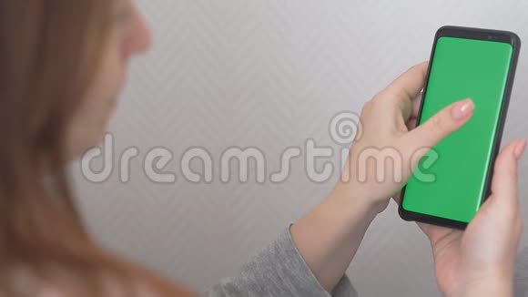 使用绿色屏幕智能手机的女性女性手滚动页面轻触触摸屏俯视图彩色键视频的预览图