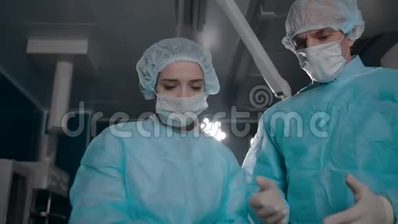 两名穿长袍的外科医生准备手术设备视频的预览图