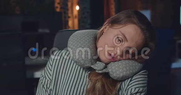 晚上办公室里睡着带枕头的疲惫的女商人女孩工作狂入睡的肖像视频的预览图