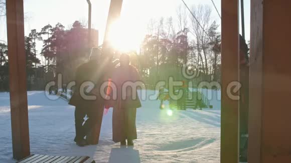 俄罗斯民间穿着民俗服装的女人正在冬季公园里骑着秋千视频的预览图