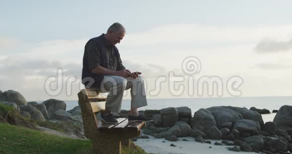 老人坐在长凳上用手机视频的预览图