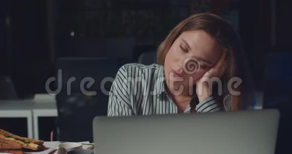 在笔记本电脑上长时间工作时女人几乎睡着了累得昏昏欲睡的女上班族视频的预览图