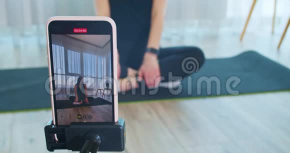 从电话里看到一个女人教一个在线瑜伽课程4k视频的预览图