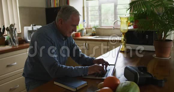 在家使用笔记本电脑和手机的老人视频的预览图