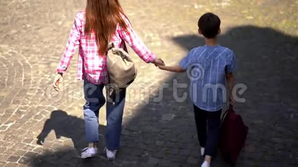 母子俩牵着手走着鹅卵石路视频的预览图