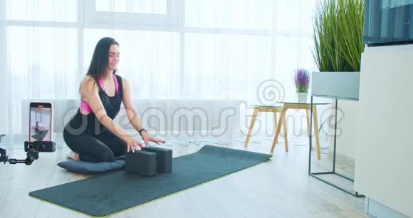 年轻女子正在现场直播瑜伽拉伸4k等在线课程视频的预览图
