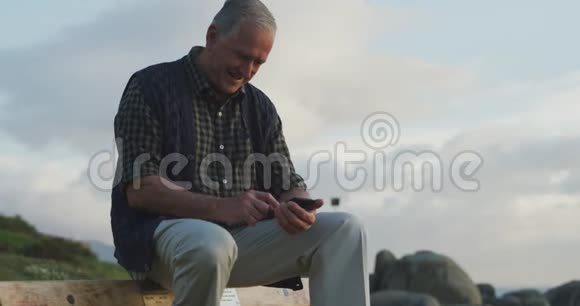 老人坐在长凳上用手机视频的预览图