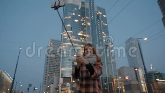年轻女性在夜间现代市中心背景下自拍视频的预览图
