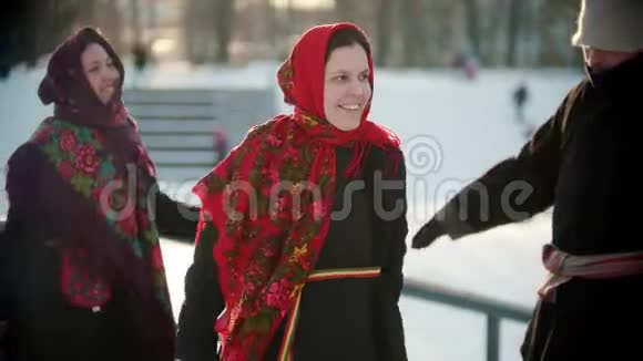 俄罗斯民间传说公园里冬天穿着鲜艳衣服的人正在跳舞视频的预览图
