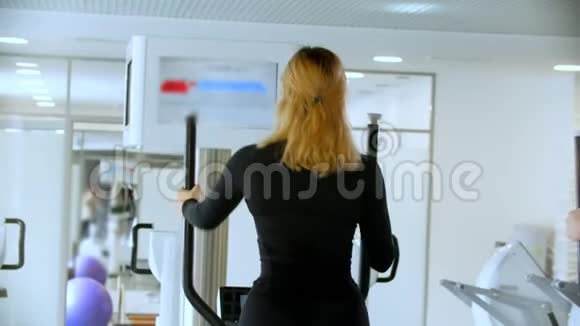 一位穿着黑色衣服的年轻女子骑着自行车做运动视频的预览图