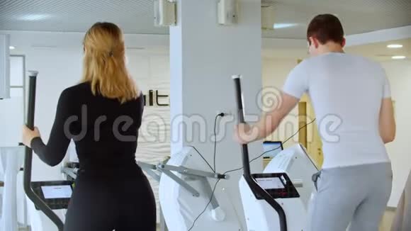 现代健身房一个年轻人和一个女人正在健身房里努力做早操视频的预览图