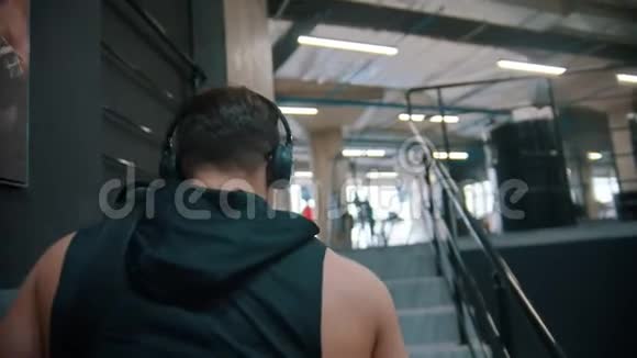 一个健美男子走在楼梯上去健身房视频的预览图