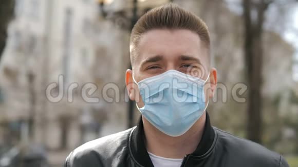英俊的欧洲男人在街上戴着医疗面罩预防感染流感病毒或视频的预览图