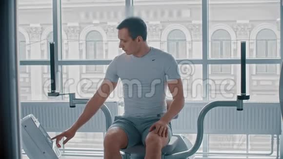 现代健身房一个人坐在训练仪器上等待何时开始视频的预览图