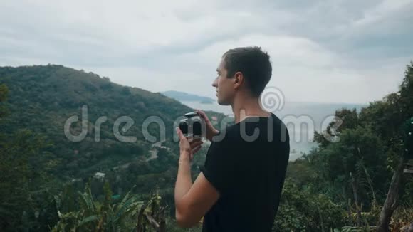 游客在山上拍摄风景如画的风景男子游客在户外用相机拍照专业人员视频的预览图