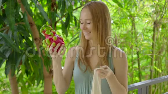 年轻女子把一些龙果放进一个可重复使用的袋子里减少塑料污染的概念减少和再利用视频的预览图