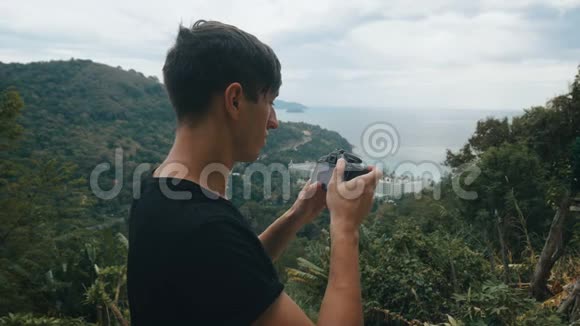游客在山上拍摄风景如画的风景男子游客在户外用相机拍照专业人员视频的预览图