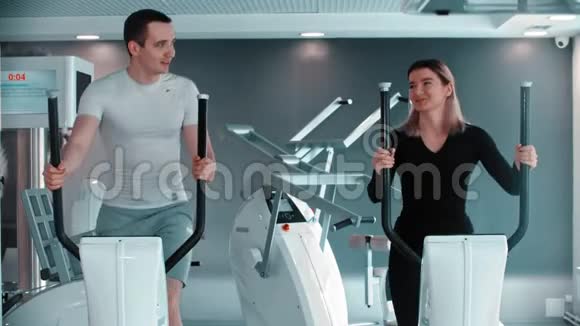现代健身房一个男人和一个女人在健身房做早操和说话视频的预览图