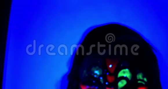 有着绿色舌头的年轻女子正在舔着相机紫外线4k视频的预览图