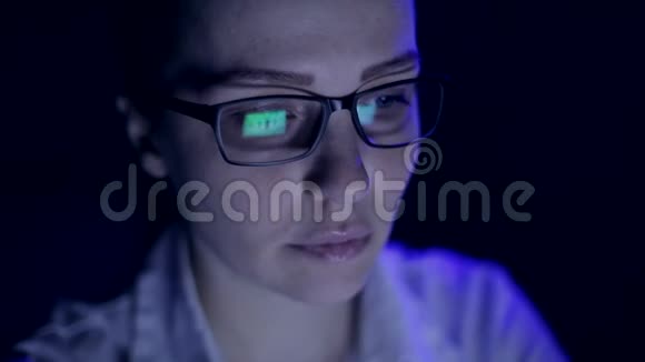 后来一个女人在笔记本电脑上工作监控眼镜里的反光视频的预览图