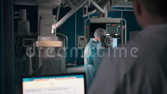 医生在实验室透过窗户看手术视频的预览图