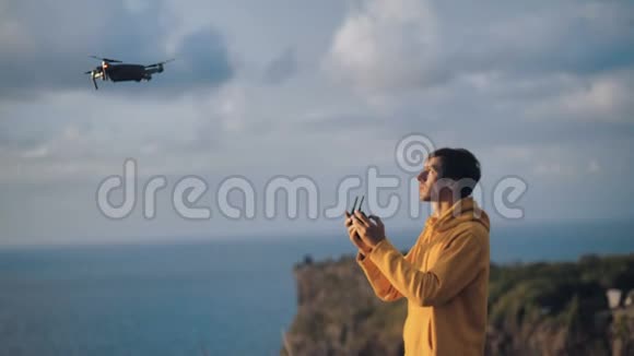 一人游客控制创新航空无人驾驶飞机年轻旅客使用连接手机的面板视频的预览图